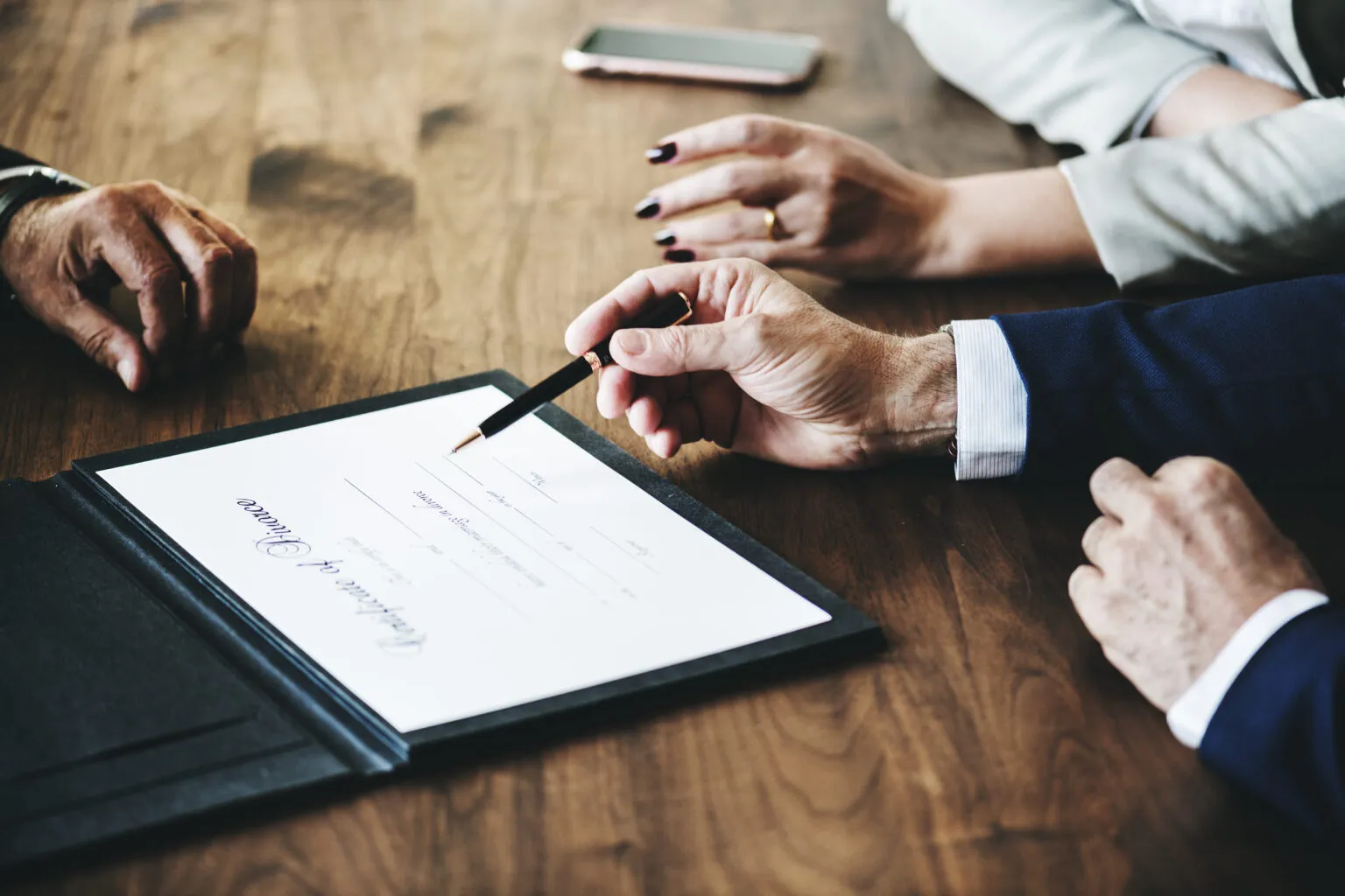 Gros plan sur la signature d'un contrat de prévoyance funéraire à deux mains