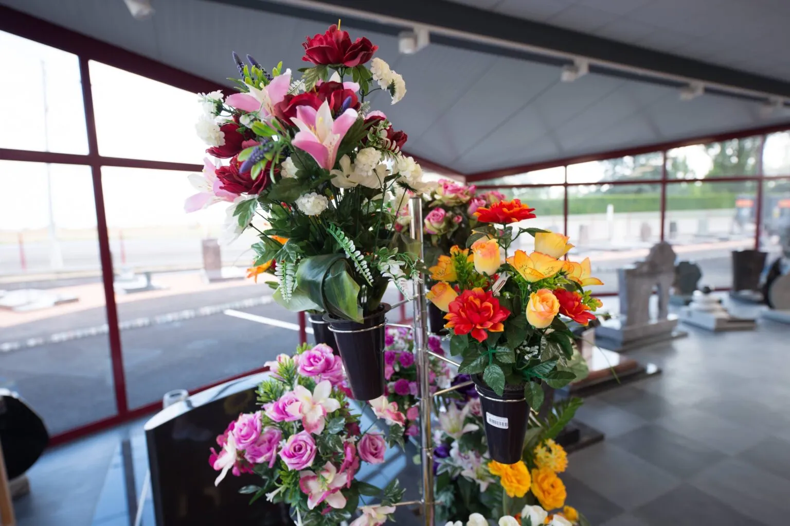 Exposition de fleurs artificielles colorées et bouquets de deuil dans une maison funéraire