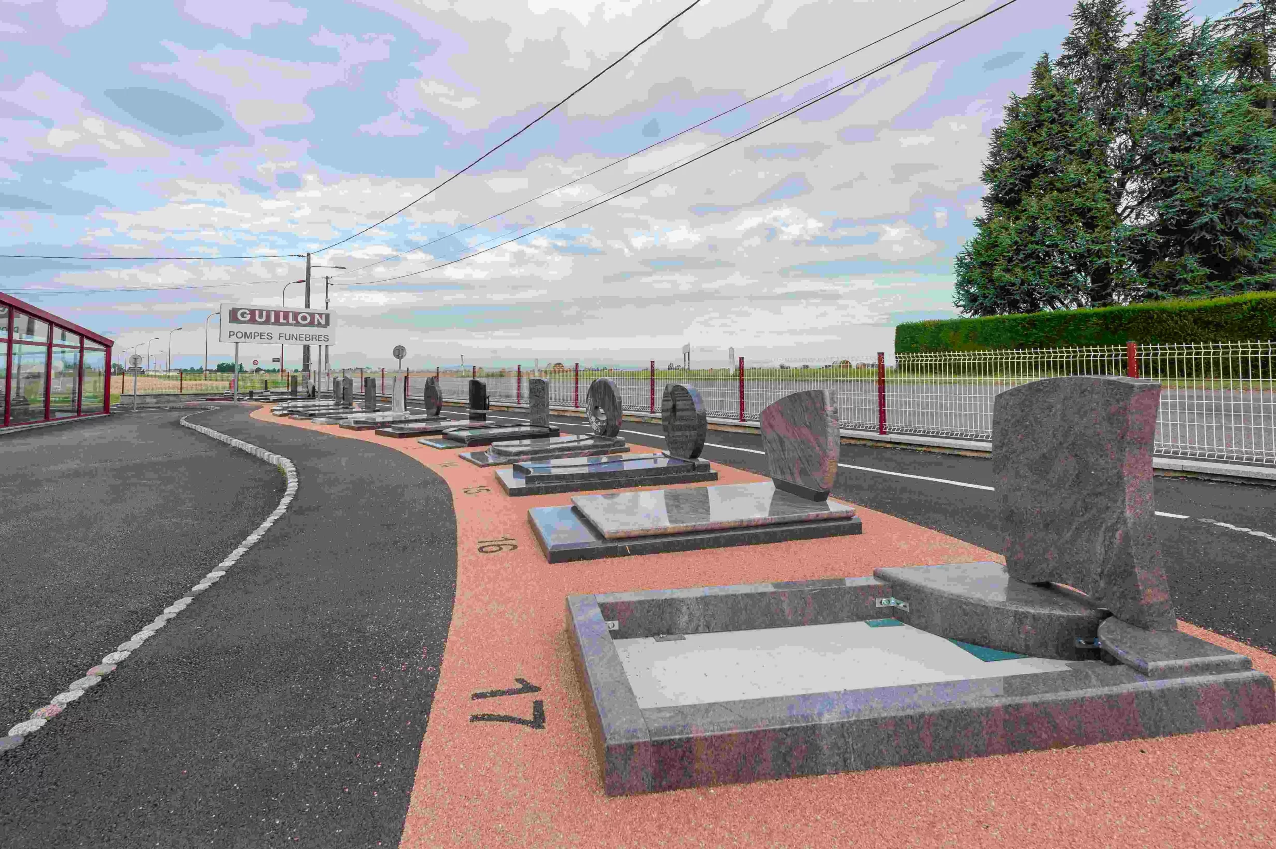 Allée d’exposition présentant divers modèles de monuments et pierres tombales en marbrerie