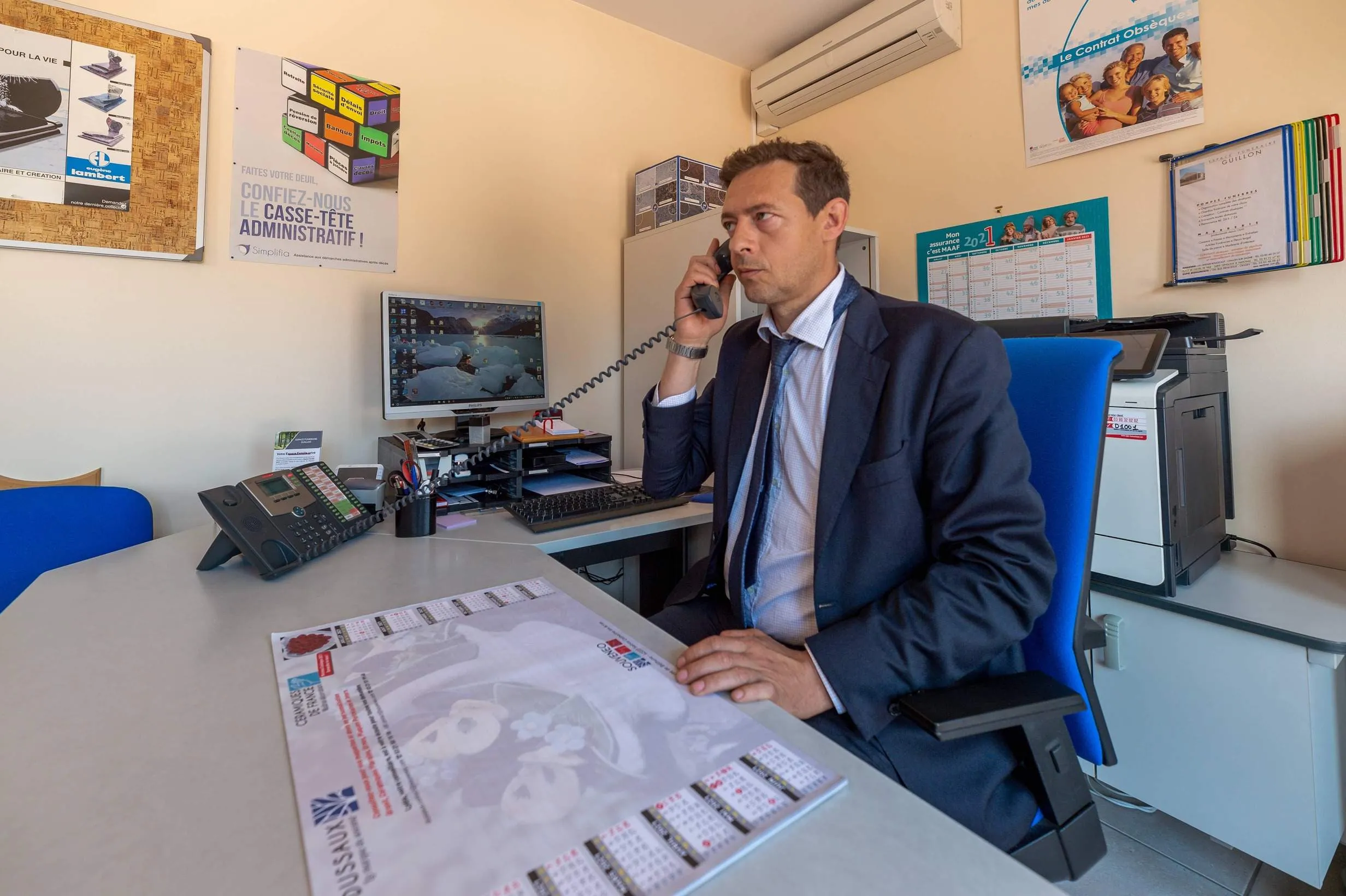 Conseiller funéraire au téléphone dans son espace de travail